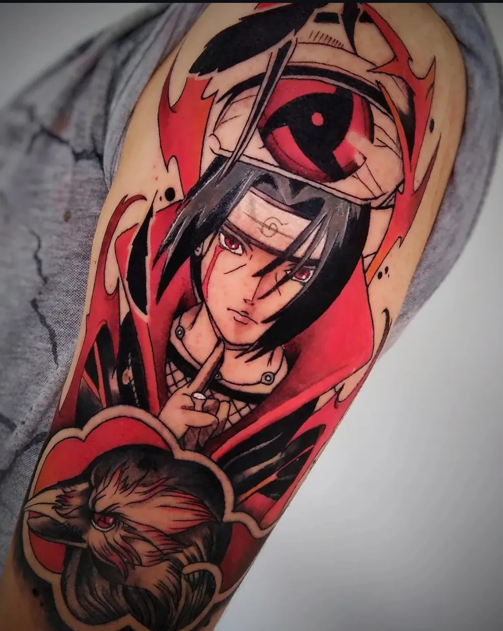 Tatuaje a color de un personaje de anime con detalles en rojo y negro